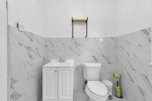 a white bathroom with a toilet and a sink at 5-Bed Home Game Room Pool Table Sleeps 13 in Buffalo +45 photos