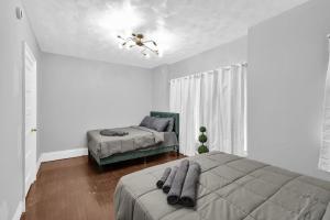 a white bedroom with a bed and a window at 5-Bed Home Game Room Pool Table Sleeps 13 in Buffalo