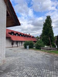 a building with a red roof and a courtyard at Penzion Skřítkův grunt in Struhařov