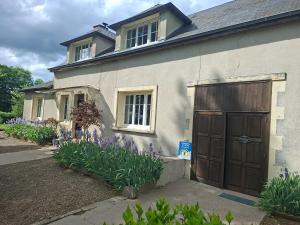 a house with a brown door and purple flowers at C'est Si Bon in Vandenesse +16 photos