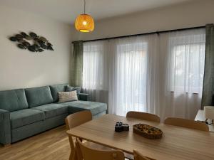 a living room with a table and a couch at Best Apartman Lelle 2 in Balatonlelle