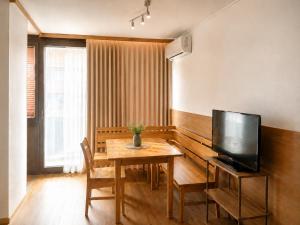 a dining room with a table and a television at Alpen Home Room 20 in Kaprun