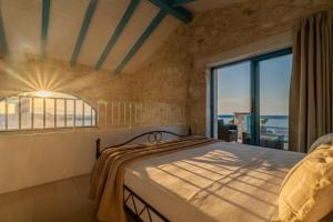 a bedroom with a bed and a large window at Kyanorama Villa, A Seaside Escape in Tragaki +38 photos
