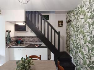 a kitchen and a staircase with a sink and a table at La Courée d'Orchies in Loos