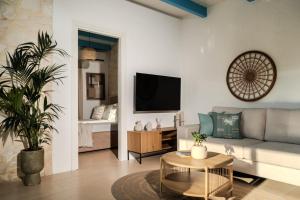 a living room with a couch and a tv at Kyanorama Villa, A Seaside Escape in Tragaki