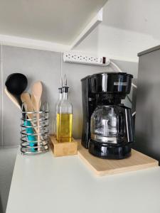 a kitchen counter with a coffee maker on a shelf at Marsella Rest House in Sitio del Niño