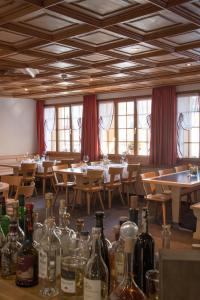 a dining room with tables and bottles of wine at Hotel Central in Obersaxen
