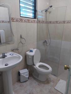 a bathroom with a toilet and a sink and a shower at Sunshine Hotel - Puerto Plata in San Felipe de Puerto Plata