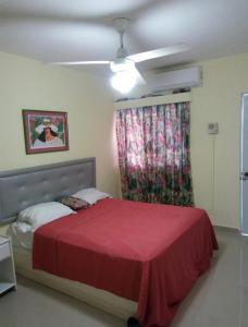 a bedroom with a red bed and a window at Sunshine Hotel - Puerto Plata in San Felipe de Puerto Plata