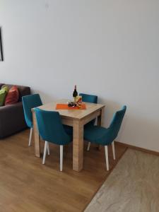 a dining room table with blue chairs and a couch at Apartman Vesna in Budva