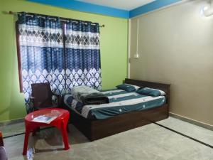 a bedroom with a bed and a red chair at Sharma Residency in Dithur