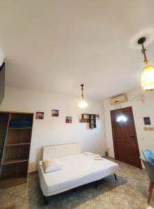a bedroom with a white bed and a wooden door at A & K Vacation House in Város