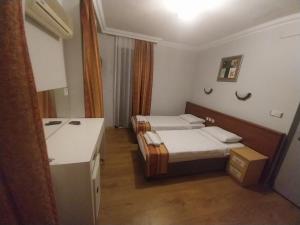 a small room with two beds and a counter at London House Hotel in Kemer