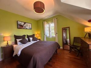 a bedroom with a large bed with green walls at Le Clos Ker'hadenn, chambres d'hôtes à Saint-Pierre Quiberon, à deux pas de la plage in Saint-Pierre-Quiberon