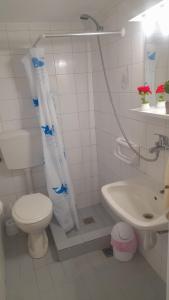 a white bathroom with a toilet and a sink at Arena's nest in Áyioi Dhéka