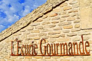 a sign on the side of a brick building at L'Ecurie Gourmande in Thaon