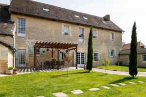 a large stone building with a picnic table in the yard at L'Ecurie Gourmande in Thaon