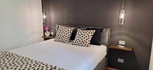 a bedroom with a bed with black and white pillows at Luana in Caltagirone