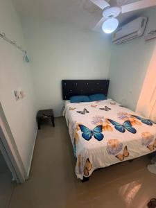 a bedroom with a bed with butterflies on it at Hostal mar de luna in Pedernales