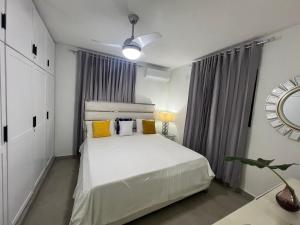 a bedroom with a white bed with yellow pillows at Villa Donatella Bonao in Bonao +30 photos