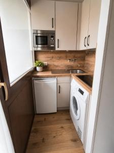 a small kitchen with a washer and dryer at Alpen Home Room 20 in Kaprun