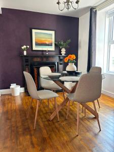 a dining room with a table and chairs and a fireplace at The Millstone in Buncrana +2 photos