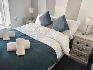 a bedroom with a large bed with towels on it at The Millstone in Buncrana