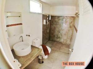 a bathroom with a white sink and a toilet at The Box House in Krabi town
