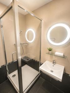a bathroom with a shower and a sink and a mirror at Alpen Home Room 20 in Kaprun