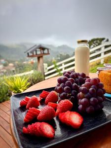 a plate of strawberries and berries on a table at chalé com Hidro e Vista panorâmica para Serra in Paraisópolis