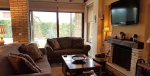 a living room with a couch and a tv at Mountain Chalet Livadi in Arachova