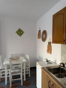 a kitchen with a sink and a table with chairs at N'Gjaci Guest House in Tale