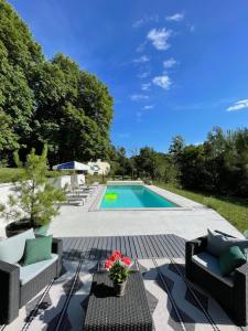 a swimming pool with two chairs and a table at Stunning Boutique gîte Flore at Vive le Vert in Bussière-Badil