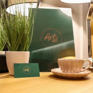 a cup of coffee sitting on a table next to a plate at Arts Apartments City Center in Krakow