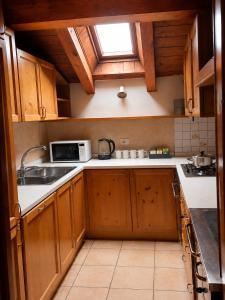 a kitchen with a sink and a microwave at APPARTAMENTO ROEN - Val di Non in Cavareno
