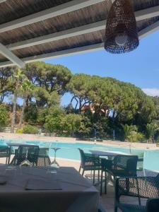 a restaurant with tables and chairs next to a pool at Grazioso monolocale Isola d'Elba in Capo D'Arco