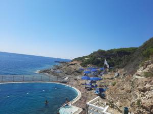a beach with umbrellas and people swimming in the water at Grazioso monolocale Isola d'Elba in Capo D'Arco +3 photos