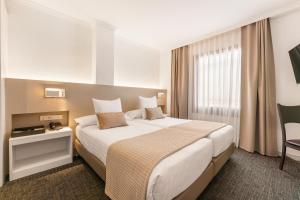 a hotel room with a large bed and a window at Acacia Suite in Barcelona +31 photos