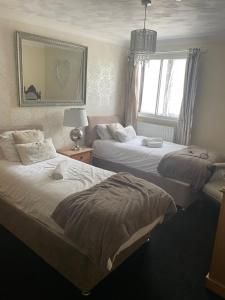 a bedroom with two beds and a mirror at Stopover Stoford in Stoford