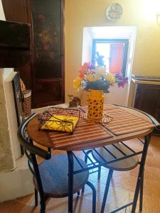 a table with a vase of flowers on top of it at Lo Chalet del Borgo in Rivisondoli