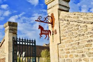 a sign on the side of a building with a fence at L'Ecurie Gourmande in Thaon +29 photos