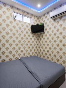 a bedroom with a bed in a room with a wall at Zamin Hotel in Shahrisabz