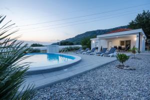 a backyard with a swimming pool and a house at Villa Nature in Čapljina
