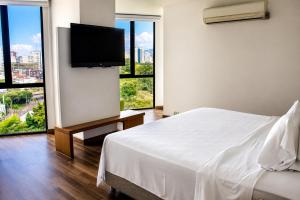 a bedroom with a white bed and a flat screen tv at Alko Select in Cali