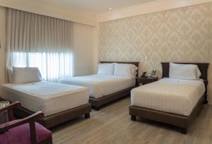 a hotel room with two beds and a window at Hotel Castilla Real in Pereira +57 photos