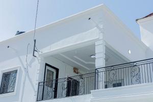 a balcony of a white house with a railing at Sowe's Villa in Old Yundum