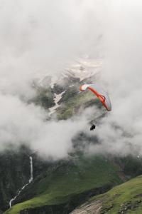 a person is flying in the sky with a parachute at Aurelia Ridge in Bīr