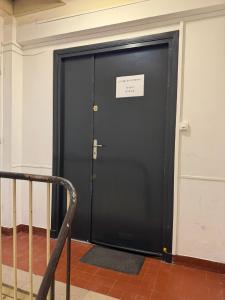 a black door with a sign on it at Le logis de la Marina in Calais