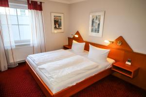 a bedroom with a large bed with white sheets at 3C-Appartements in Scharbeutz