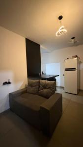 a living room with a couch and a refrigerator at Loft 4 Mobiliado e Individual com Garagem 3min do centro in Dourados